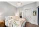 Cozy main bedroom features hardwood floors, light gray walls, chandelier, and view into ensuite bathroom at 1055 Piedmont Ne Ave # 106, Atlanta, GA 30309