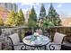 Outdoor patio with stone retaining wall, table with seating for four, and views of trees and skyline at 1055 Piedmont Ne Ave # 106, Atlanta, GA 30309