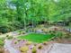 Expansive backyard featuring mature trees, wooden bridges, a stone path, and lush greenery at 4853 Carlene Sw Way, Lilburn, GA 30047