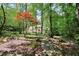 Lush backyard featuring mature trees, and a view of home behind trees at 4853 Carlene Sw Way, Lilburn, GA 30047