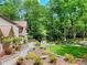 Manicured backyard with stone pathway, bridge, lush garden, and wooded backdrop at 4853 Carlene Sw Way, Lilburn, GA 30047