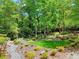 Manicured backyard featuring lush garden and wooded backdrop at 4853 Carlene Sw Way, Lilburn, GA 30047