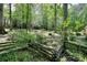 Wooded backyard featuring a stone pathway and bridge leading to a private retreat at 4853 Carlene Sw Way, Lilburn, GA 30047