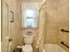 Cozy bathroom featuring a toilet and bathtub with classic tile, complemented by natural light from the window at 4853 Carlene Sw Way, Lilburn, GA 30047