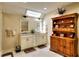 Bathroom featuring a double sink vanity, a skylight, and decorative accents at 4853 Carlene Sw Way, Lilburn, GA 30047