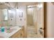 Charming bathroom featuring a marble vanity, bright lighting, and a glimpse into a classic, tiled shower at 4853 Carlene Sw Way, Lilburn, GA 30047