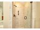 Close-up of tiled shower with glass door and bronze fixtures in updated bathroom at 4853 Carlene Sw Way, Lilburn, GA 30047