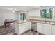 Bright eat-in kitchen boasts stainless steel dishwasher, updated cabinets, and views of a lush backyard at 6249 Townsend Way, Riverdale, GA 30296