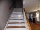 Staircase leading to a spacious living area, featuring white painted risers and a wooden banister at 1378 Lucile Sw Ave, Atlanta, GA 30310