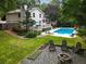 Expansive backyard features a swimming pool, fire pit and outdoor seating, all set within a lush, green landscape at 215 Ansley Ct, Roswell, GA 30076