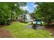 Expansive backyard with mature trees and landscaping, featuring a fire pit and ample space for recreation at 215 Ansley Ct, Roswell, GA 30076