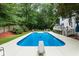 Backyard view of pool, patio, privacy fence, landscaping, and outdoor seating and dining area at 215 Ansley Ct, Roswell, GA 30076