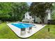 Home exterior showcases a spacious pool, lounge chairs, a well maintained backyard, and lush landscaping at 215 Ansley Ct, Roswell, GA 30076