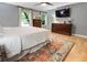 Bedroom featuring hardwood floors, a comfortable queen bed, and ample natural light at 215 Ansley Ct, Roswell, GA 30076
