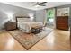 Spacious bedroom with hardwood floors, a comfortable queen bed, and ample natural light at 215 Ansley Ct, Roswell, GA 30076