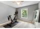 Bedroom features a stationary bicycle, light gray walls, and neutral decor at 215 Ansley Ct, Roswell, GA 30076
