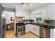 Well-lit kitchen featuring white cabinets, stainless steel appliances, and stylish tile backsplash at 215 Ansley Ct, Roswell, GA 30076