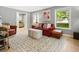 Cozy living room featuring comfortable seating, bright windows, and a stylish area rug over gleaming hardwood floors at 215 Ansley Ct, Roswell, GA 30076