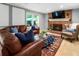 Inviting living room boasts a brick fireplace, large leather sofa and stylish decor at 215 Ansley Ct, Roswell, GA 30076