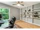Office area features a glass desk, hardwood floors and custom built-in shelving at 215 Ansley Ct, Roswell, GA 30076
