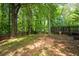 Spacious backyard featuring a wood deck and wooded perimeter, offering privacy and outdoor living space at 496 Bottesford Nw Dr, Kennesaw, GA 30144