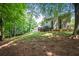 Exterior view of home with a tiered backyard and spacious deck, surrounded by mature trees at 496 Bottesford Nw Dr, Kennesaw, GA 30144