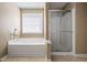 Bathroom features a bathtub, shower, and large window at 496 Bottesford Nw Dr, Kennesaw, GA 30144