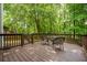 Spacious backyard deck with table and seating surrounded by trees at 496 Bottesford Nw Dr, Kennesaw, GA 30144