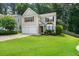 Inviting two-story home featuring a lush green lawn and mature trees at 496 Bottesford Nw Dr, Kennesaw, GA 30144
