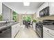 Bright kitchen with white cabinets, granite countertops, and dining area with large windows at 496 Bottesford Nw Dr, Kennesaw, GA 30144