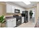 Contemporary kitchen with white cabinets and black appliances; a modern design at 496 Bottesford Nw Dr, Kennesaw, GA 30144