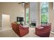 Spacious living room with high ceilings, fireplace, and abundant natural light from large windows at 496 Bottesford Nw Dr, Kennesaw, GA 30144