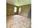 Bedroom with plywood floors, wood paneling, window, and view to the bathroom at 9160 Carr Cir, Covington, GA 30014