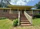 Brick home featuring a covered front porch with brick stairs and wood railings at 9160 Carr Cir, Covington, GA 30014