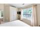 Beige bedroom with large window, ceiling fan and closet at 2011 Wildcat Lake Ct, Lawrenceville, GA 30043