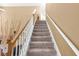 Carpeted staircase with white railings and natural wood accents leads to the upper level at 2011 Wildcat Lake Ct, Lawrenceville, GA 30043
