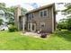 Back exterior of home with a patio, fireplace, green grass, large trees, and a brown exterior at 3554 Cherry Blossom Court, Loganville, GA 30052