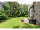 Back exterior of home with a patio, fireplace, green grass, large trees, and a brown exterior at 3554 Cherry Blossom Court, Loganville, GA 30052