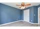 This bedroom features beautiful, blue walls, light wood floors, a ceiling fan with lights and a white door at 3554 Cherry Blossom Court, Loganville, GA 30052