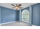Bedroom features light-colored laminate floors, blue walls, large window with curtains, and ceiling fan at 3554 Cherry Blossom Court, Loganville, GA 30052