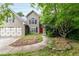 Inviting two-story home featuring neutral siding, two-car garage, red front door, and mature landscaping at 3554 Cherry Blossom Court, Loganville, GA 30052