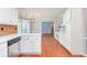 Open kitchen with white cabinets, stainless steel dishwasher and view to the living area at 3554 Cherry Blossom Court, Loganville, GA 30052