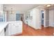 Bright kitchen with white cabinetry and hardwood floors; view to arched doorway at 3554 Cherry Blossom Court, Loganville, GA 30052