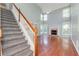 Bright living room with hardwood floors, staircase, fireplace, and large windows at 3554 Cherry Blossom Court, Loganville, GA 30052
