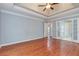 Bedroom with tray ceiling, hardwood floors, and multiple doorway views at 3554 Cherry Blossom Court, Loganville, GA 30052