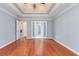 Large bedroom with tray ceiling, hardwood floors, and multiple doorway views at 3554 Cherry Blossom Court, Loganville, GA 30052