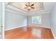 Bedroom featuring tray ceiling, hardwood floors, and a large window at 3554 Cherry Blossom Court, Loganville, GA 30052