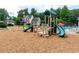 This community playground has play structures and mature trees with a pool and lounge chairs in the background at 3554 Cherry Blossom Court, Loganville, GA 30052