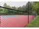 This community tennis court is surrounded by a black fence and lush green trees at 3554 Cherry Blossom Court, Loganville, GA 30052