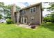 This is the home's backyard and exterior, which features lots of green grass and mature trees and a brick chimney at 3554 Cherry Blossom Ct, Loganville, GA 30052
